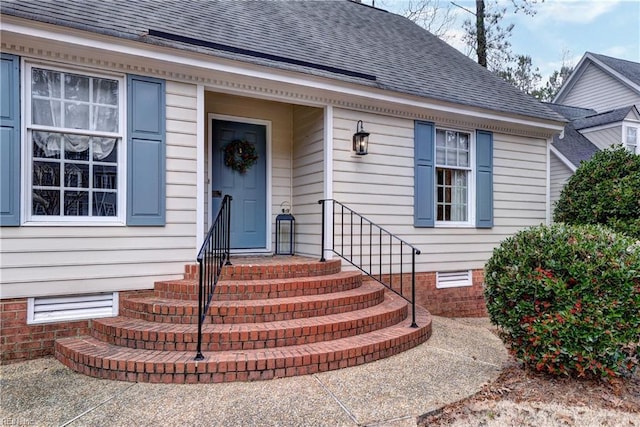 property entrance with a shingled roof and crawl space