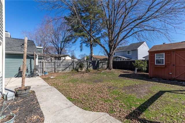 view of yard with a patio area, a shed, a fenced backyard, and an outdoor structure