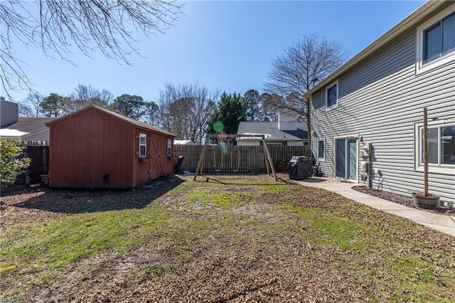 view of yard featuring an outbuilding, a fenced backyard, and a storage unit