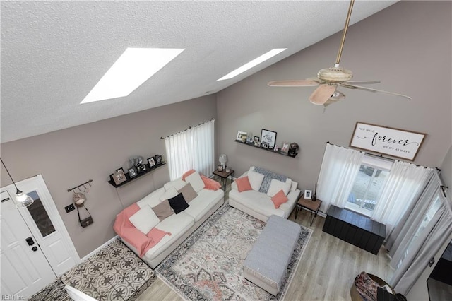 living room featuring a textured ceiling, a skylight, and wood finished floors