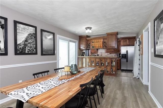 dining area with light wood-style flooring and baseboards