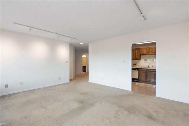 255 College Cross Rd Unit 89, Norfolk, VA 23510 - unfurnished living room featuring a sink, baseboards, track lighting, and light colored carpet