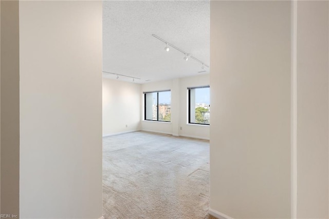 255 College Cross Rd Unit 89, Norfolk, VA 23510 - empty room with track lighting, light carpet, a textured ceiling, and baseboards