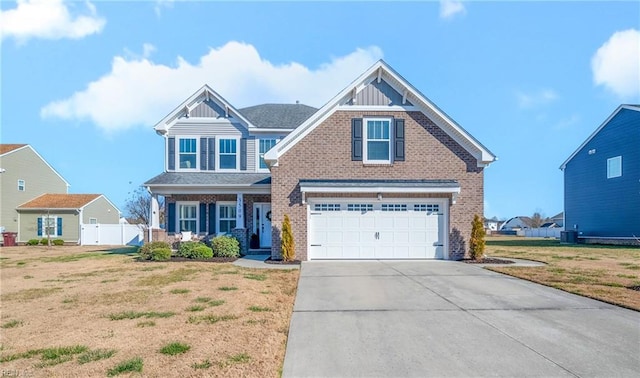 craftsman-style house featuring a garage, brick siding, fence, driveway, and a front yard