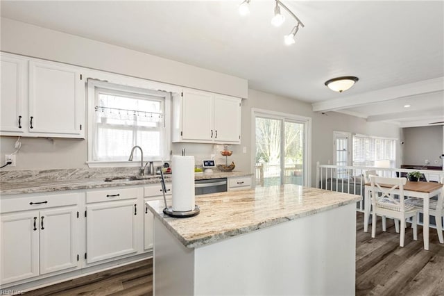 kitchen featuring dark wood finished floors, a sink, a wealth of natural light, and white cabinets