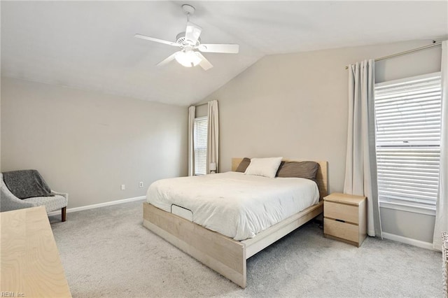 carpeted bedroom featuring lofted ceiling, multiple windows, and baseboards