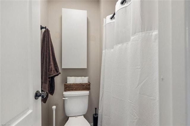 bathroom with curtained shower and toilet