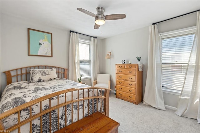 bedroom with light carpet, ceiling fan, and baseboards