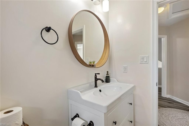 bathroom featuring wood finished floors, vanity, and baseboards