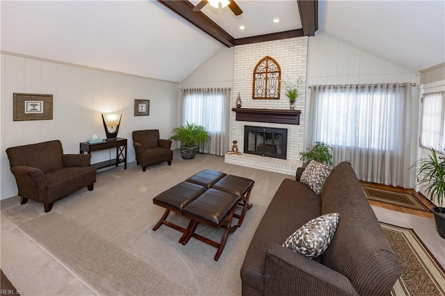 living area featuring carpet floors, a fireplace, vaulted ceiling with beams, and ceiling fan