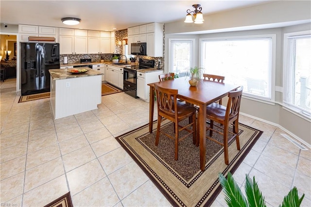 dining space with light tile patterned flooring, a wealth of natural light, and an inviting chandelier