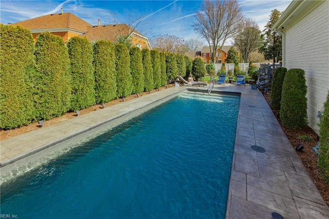 view of swimming pool featuring a patio area, a fenced backyard, and a fenced in pool