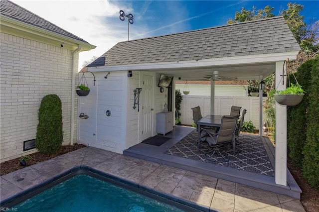 view of patio with fence, a fenced in pool, and an outdoor structure