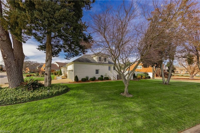 view of yard featuring an attached garage and driveway