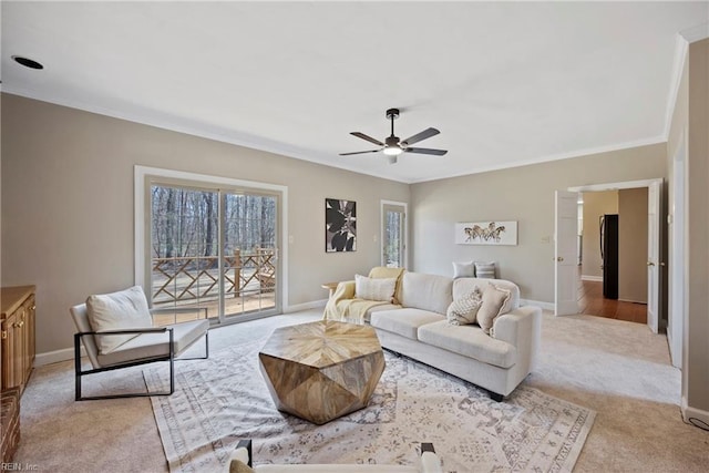 living room featuring baseboards, ornamental molding, and light colored carpet