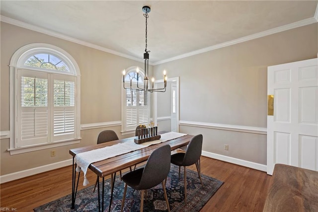 dining area with an inviting chandelier, crown molding, baseboards, and wood finished floors