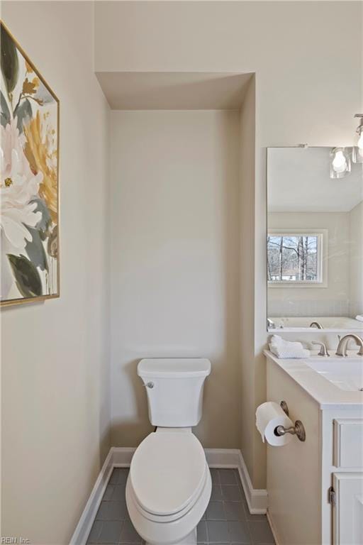 bathroom featuring toilet, tile patterned flooring, vanity, and baseboards