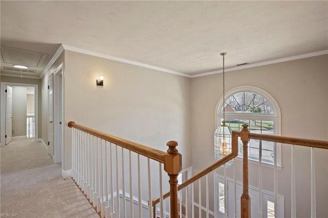 corridor featuring crown molding, attic access, light carpet, an upstairs landing, and baseboards