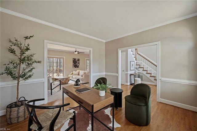 office space featuring crown molding, light wood-style flooring, and baseboards