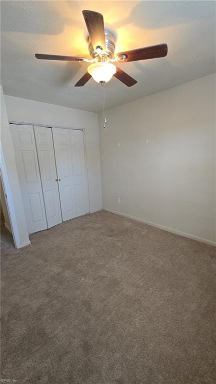 unfurnished bedroom with a closet, carpet, and a ceiling fan