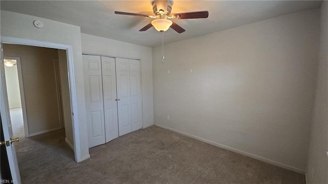 unfurnished bedroom with a closet, carpet flooring, ceiling fan, and baseboards