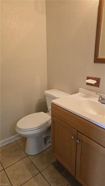 bathroom with baseboards, vanity, toilet, and tile patterned floors