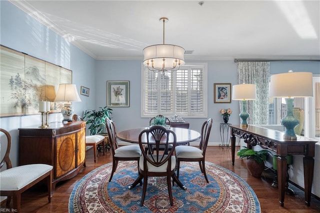 dining space featuring visible vents, ornamental molding, a notable chandelier, and wood finished floors