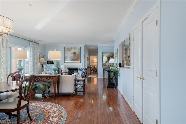 interior space featuring baseboards, a fireplace, ornamental molding, and hardwood / wood-style floors