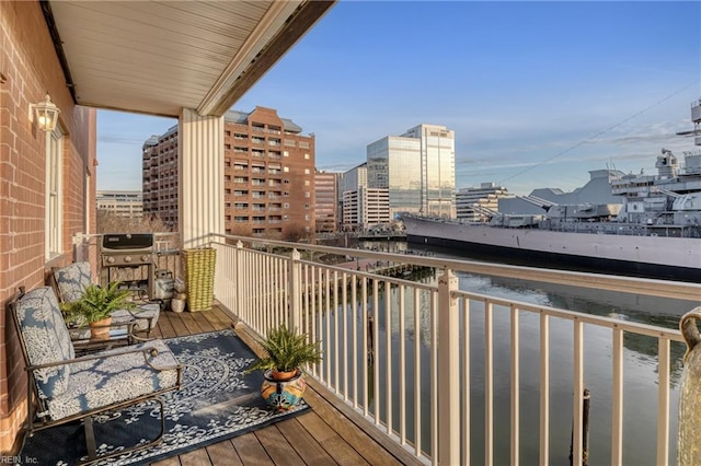 balcony with a view of city, a water view, and area for grilling