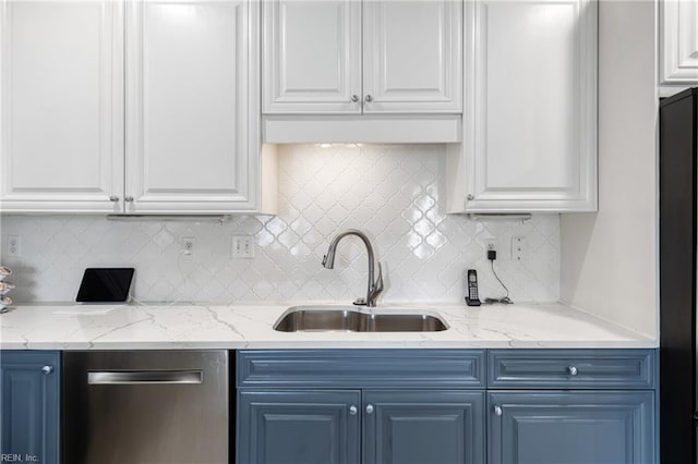 kitchen featuring backsplash, stainless steel dishwasher, white cabinets, a sink, and blue cabinets