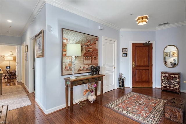 foyer entrance with ornamental molding, visible vents, baseboards, and hardwood / wood-style flooring