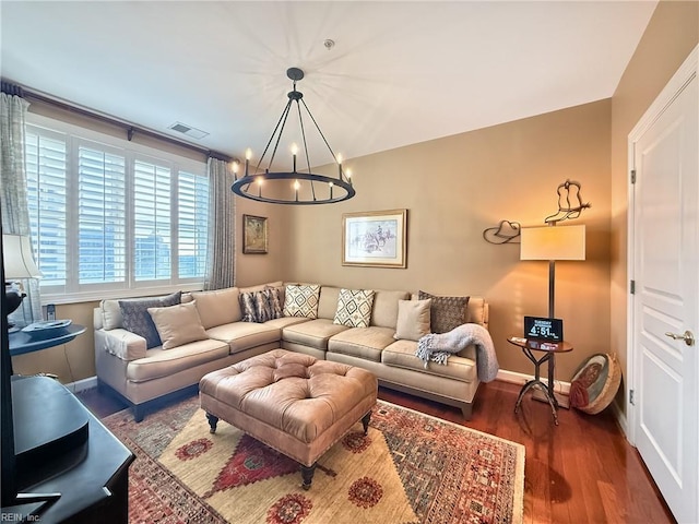 living room featuring baseboards, visible vents, a chandelier, and wood finished floors