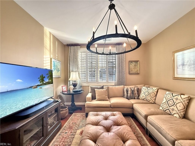 living room featuring lofted ceiling, an inviting chandelier, baseboards, and wood finished floors