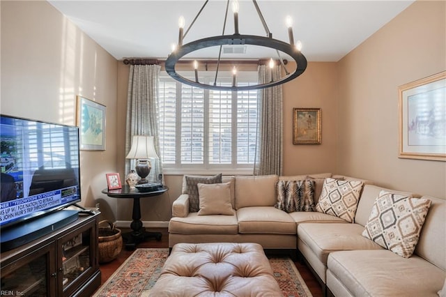 living room featuring wood finished floors, baseboards, and an inviting chandelier