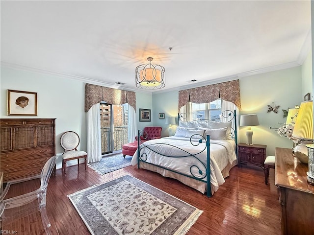 bedroom with crown molding, visible vents, and wood finished floors