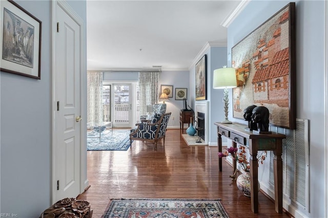 corridor featuring baseboards, wood finished floors, and crown molding