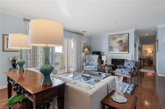 living room featuring ornamental molding, hardwood / wood-style floors, a fireplace, and baseboards