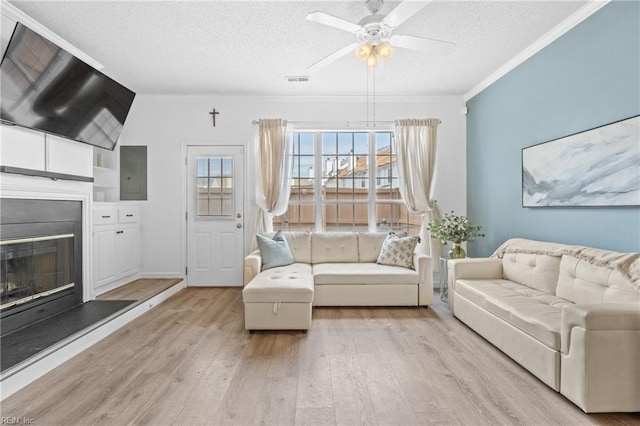 unfurnished living room featuring a fireplace, visible vents, ceiling fan, a textured ceiling, and light wood-type flooring