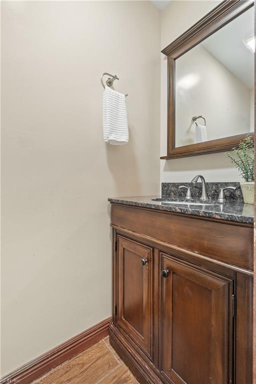 bathroom with vanity, baseboards, and wood finished floors