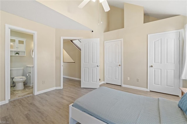 bedroom with ensuite bath, a closet, baseboards, and wood finished floors