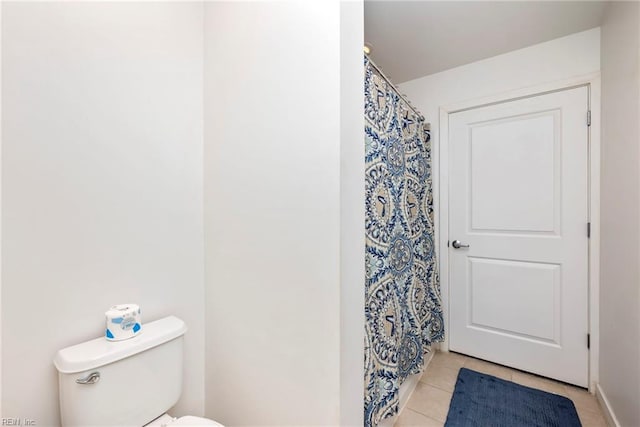 bathroom with a shower with shower curtain, toilet, and tile patterned floors