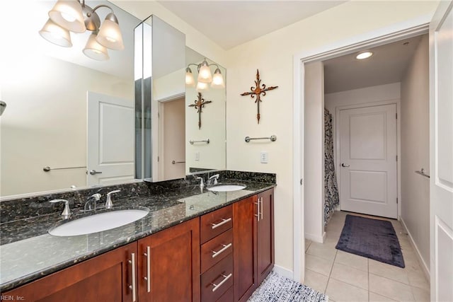 bathroom with double vanity, tile patterned flooring, a sink, and baseboards