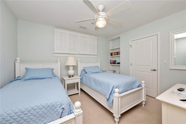 bedroom featuring a ceiling fan, visible vents, and light colored carpet