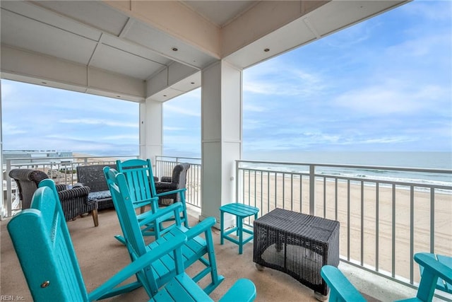 balcony featuring a water view and a beach view