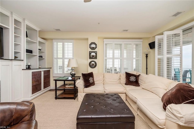 living room featuring visible vents and light colored carpet