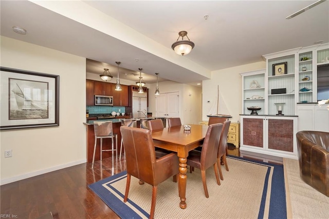 dining area with baseboards and wood finished floors