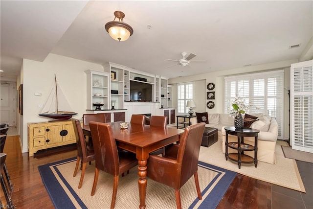 dining area with dark wood-style floors, visible vents, and a ceiling fan