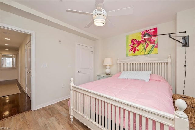 bedroom with ceiling fan, baseboards, and wood finished floors