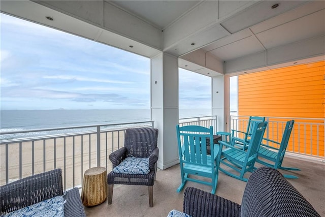 balcony with a water view and a beach view