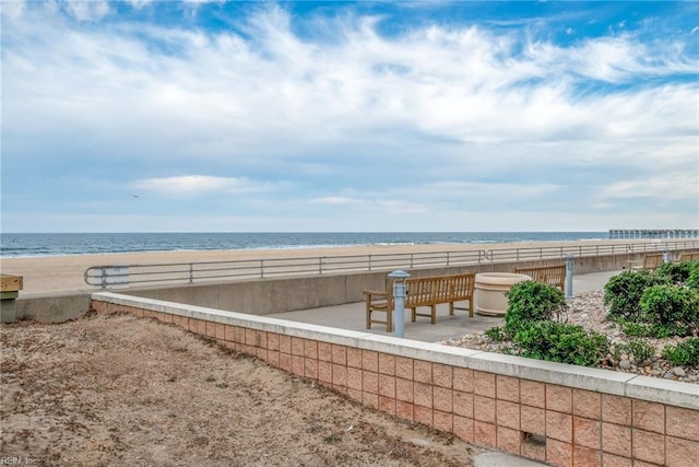 exterior space featuring a patio area, a beach view, and a water view